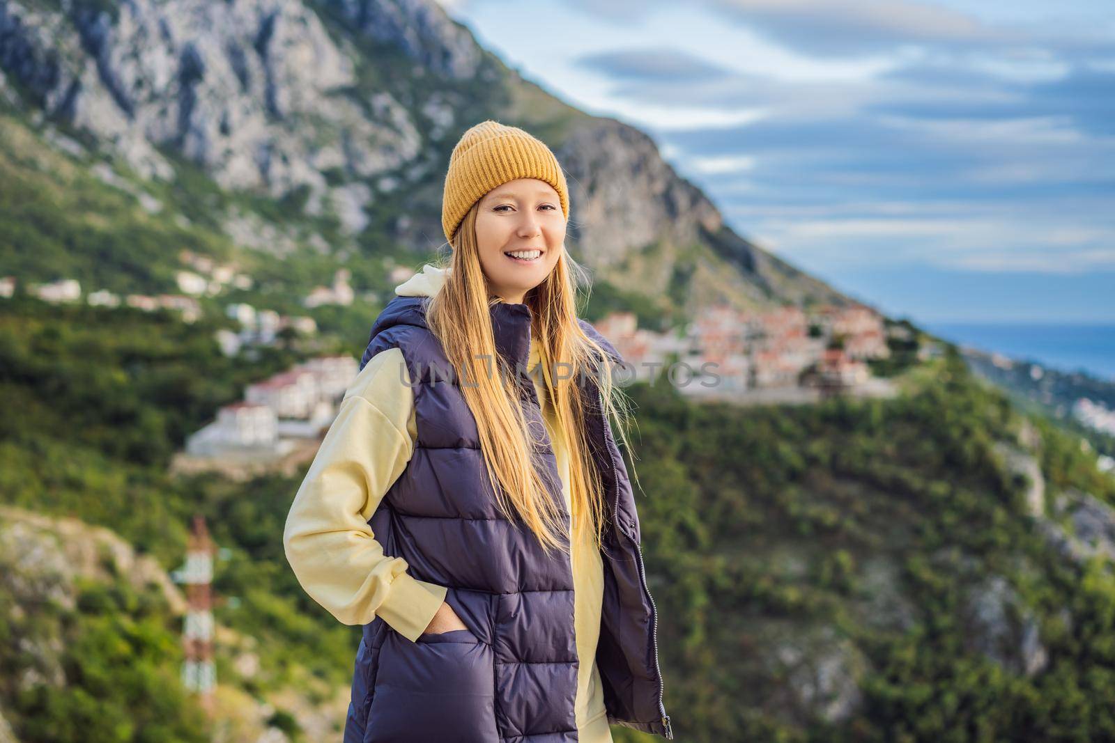 Woman in the mountains of Montenegro in warm clothes. Travel to Montenegro in spring, autumn, winter.