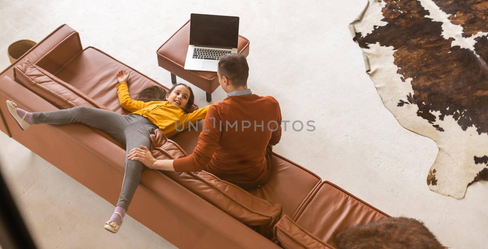 Father and daughter using laptop at home.