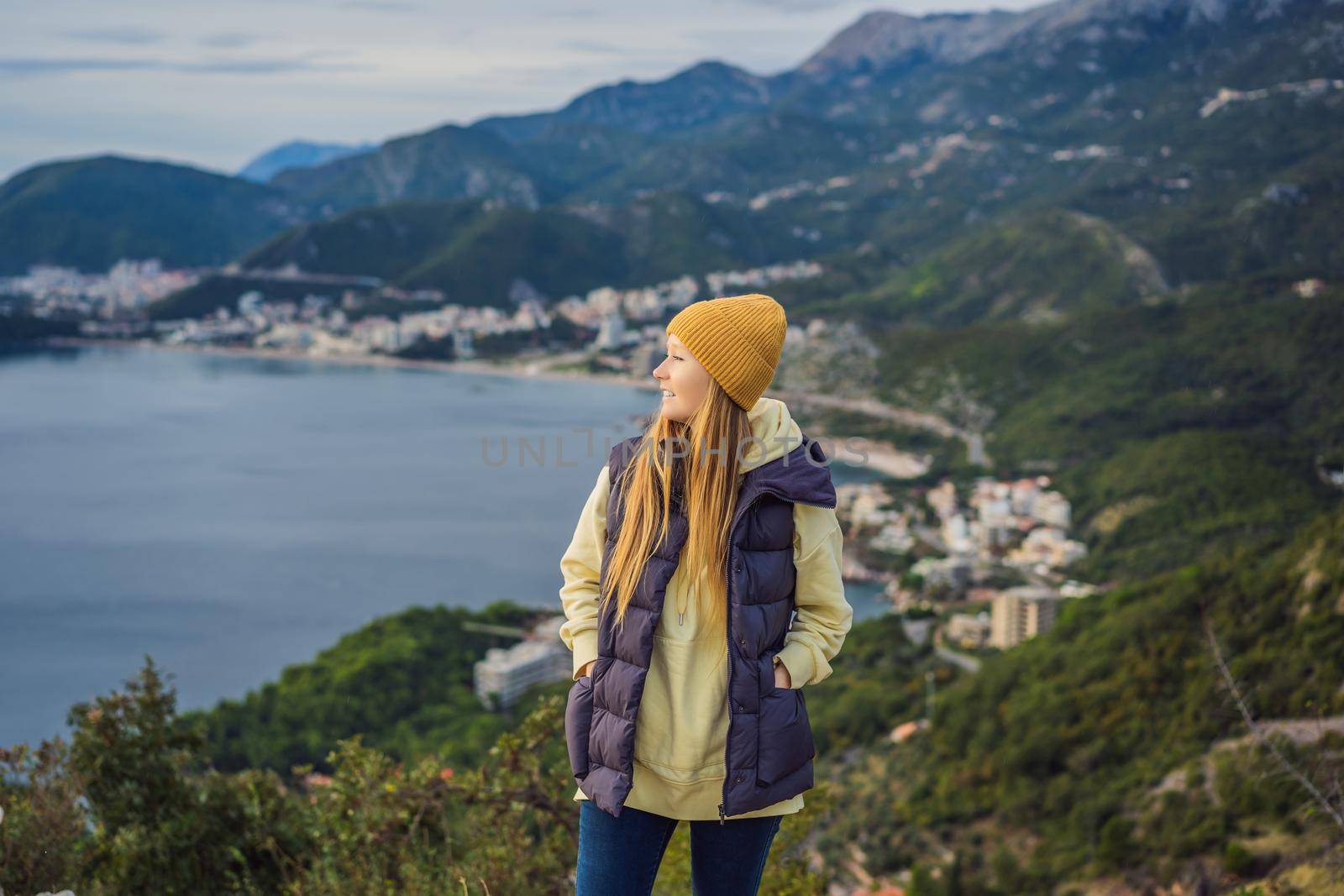 Woman in the mountains of Montenegro in warm clothes. Travel to Montenegro in spring, autumn, winter.