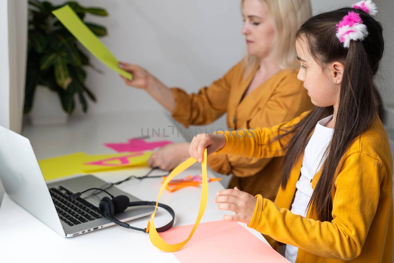 Online education of children. Mother and daughter of preschool watching a video lesson call chat creative course art drawing using lapott at home