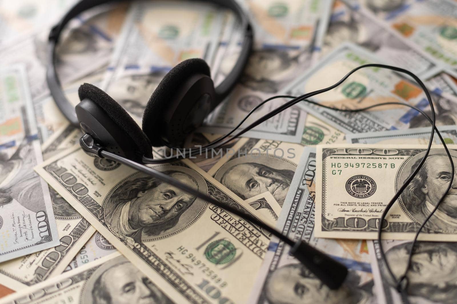 one hundred dollar bills and headphones. Close-up. by Andelov13