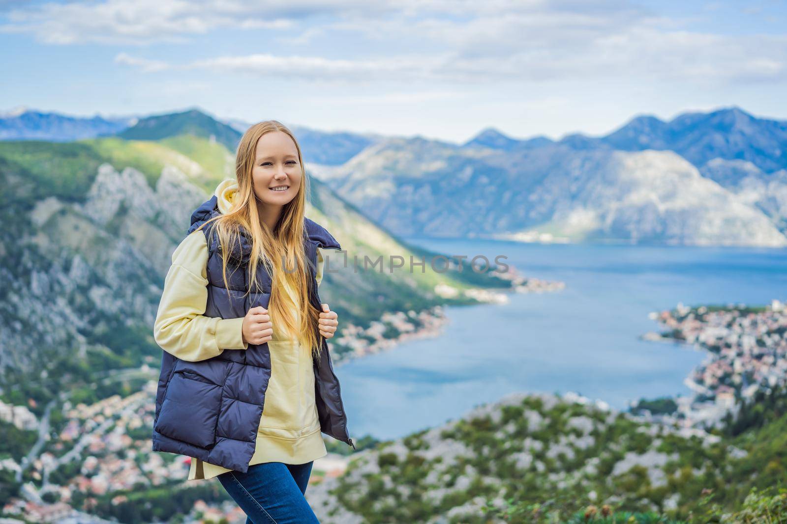 Woman tourist enjoys the view of Kotor. Montenegro. Bay of Kotor, Gulf of Kotor, Boka Kotorska and walled old city. Travel to Montenegro concept. Fortifications of Kotor is on UNESCO World Heritage List since 1979 by galitskaya