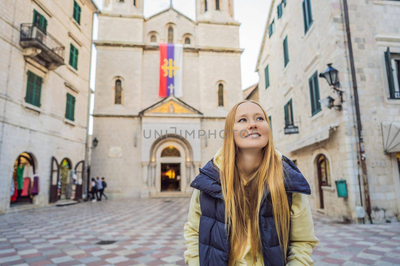 Woman tourist enjoying Colorful street in Old town of Kotor on a sunny day, Montenegro. Travel to Montenegro concept.