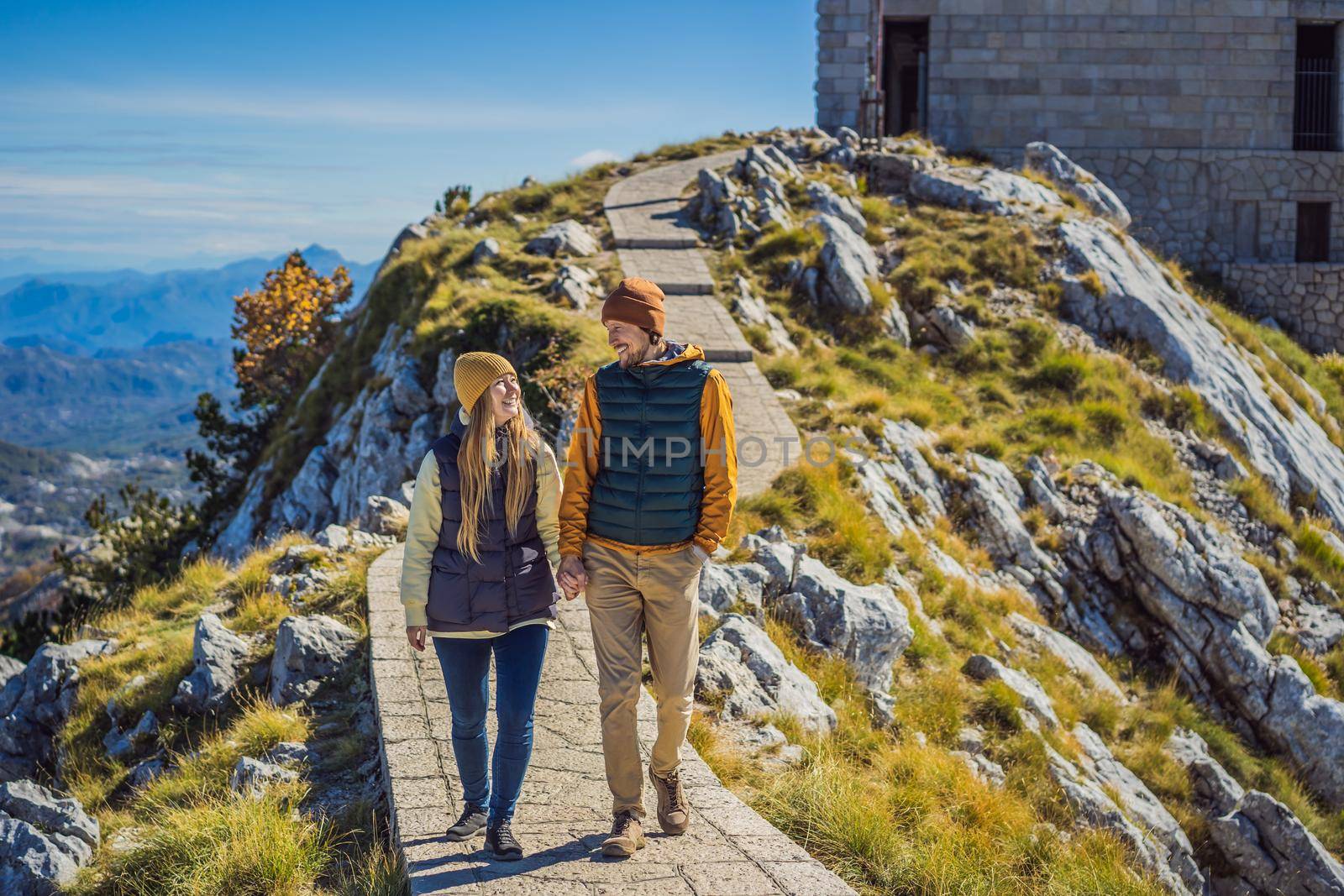 Couple man and woman tourists in mountain landscape at national park Lovcen, Montenegro. Travel to Montenegro concept.