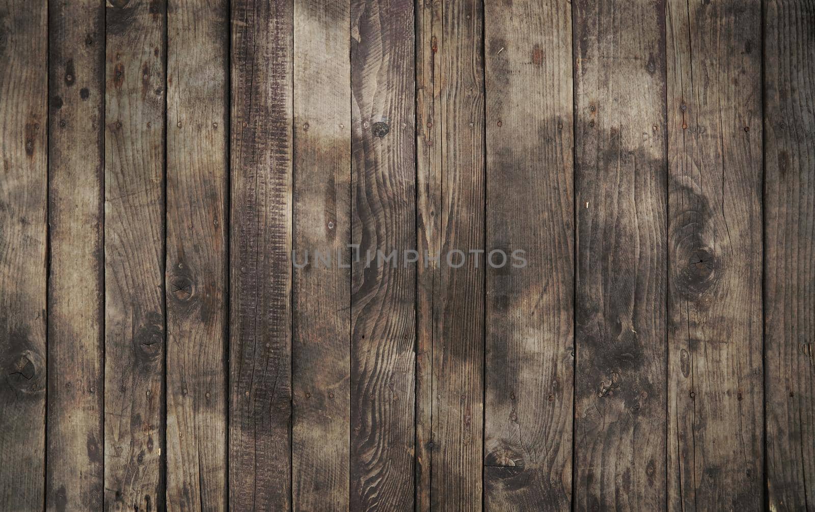 Old vintage aged grunge dark brown and gray wooden floor planks texture background with stains and nails