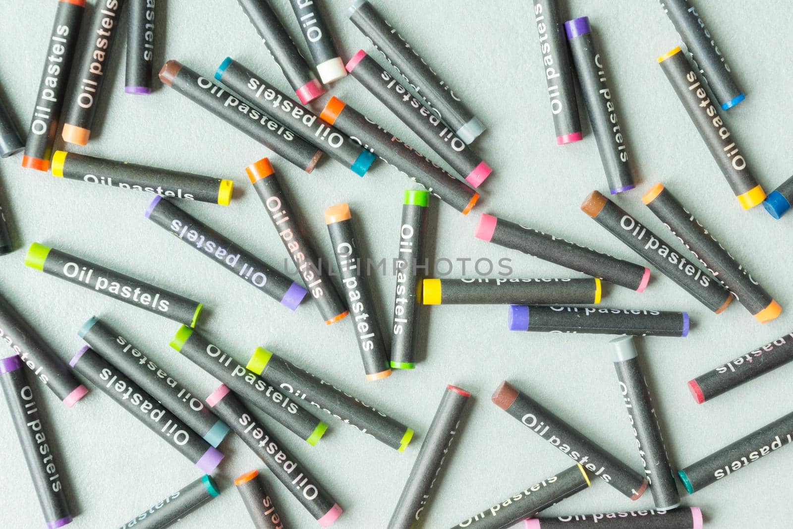 colorful oil pastel waxes arranged randomly throughout the image with gray background