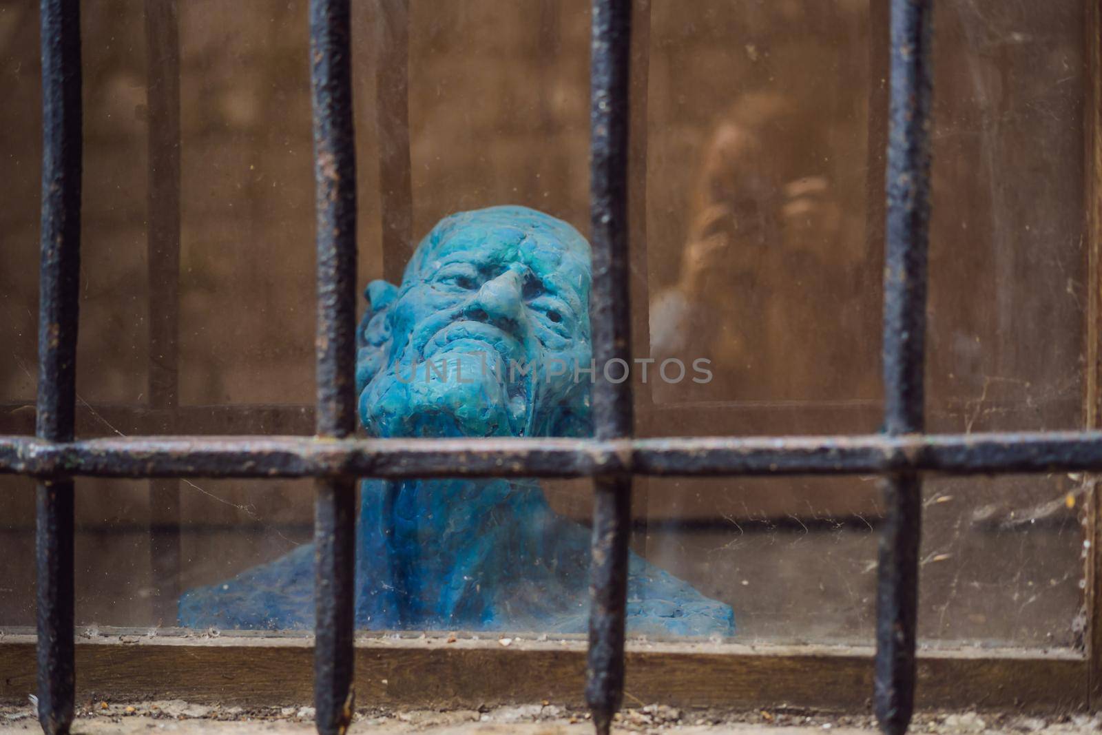 Abstract. Prisoner on a steel lattice close up. Assassin, a murderer behind the bars.