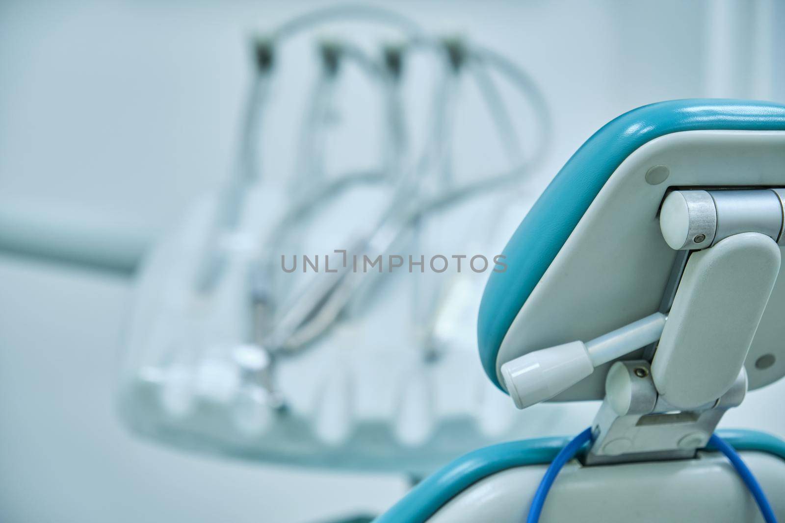 empty seat of a dental clinic with unfocused background instruments
