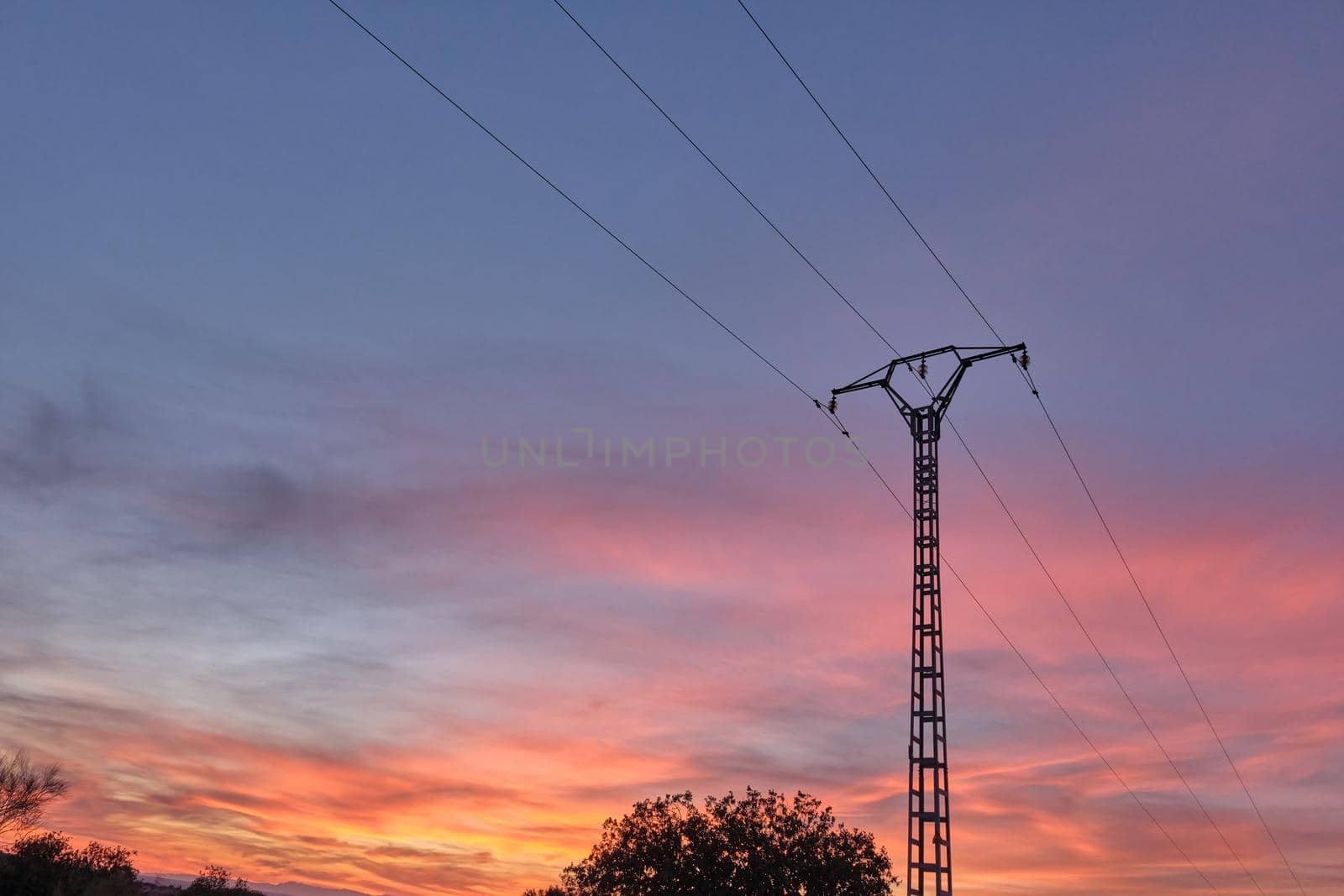 power line pole with orange sunset clouds in the background
