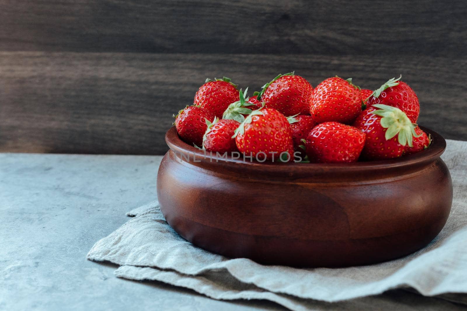 wooden bowl full of fresh strawberries by jatmikaV