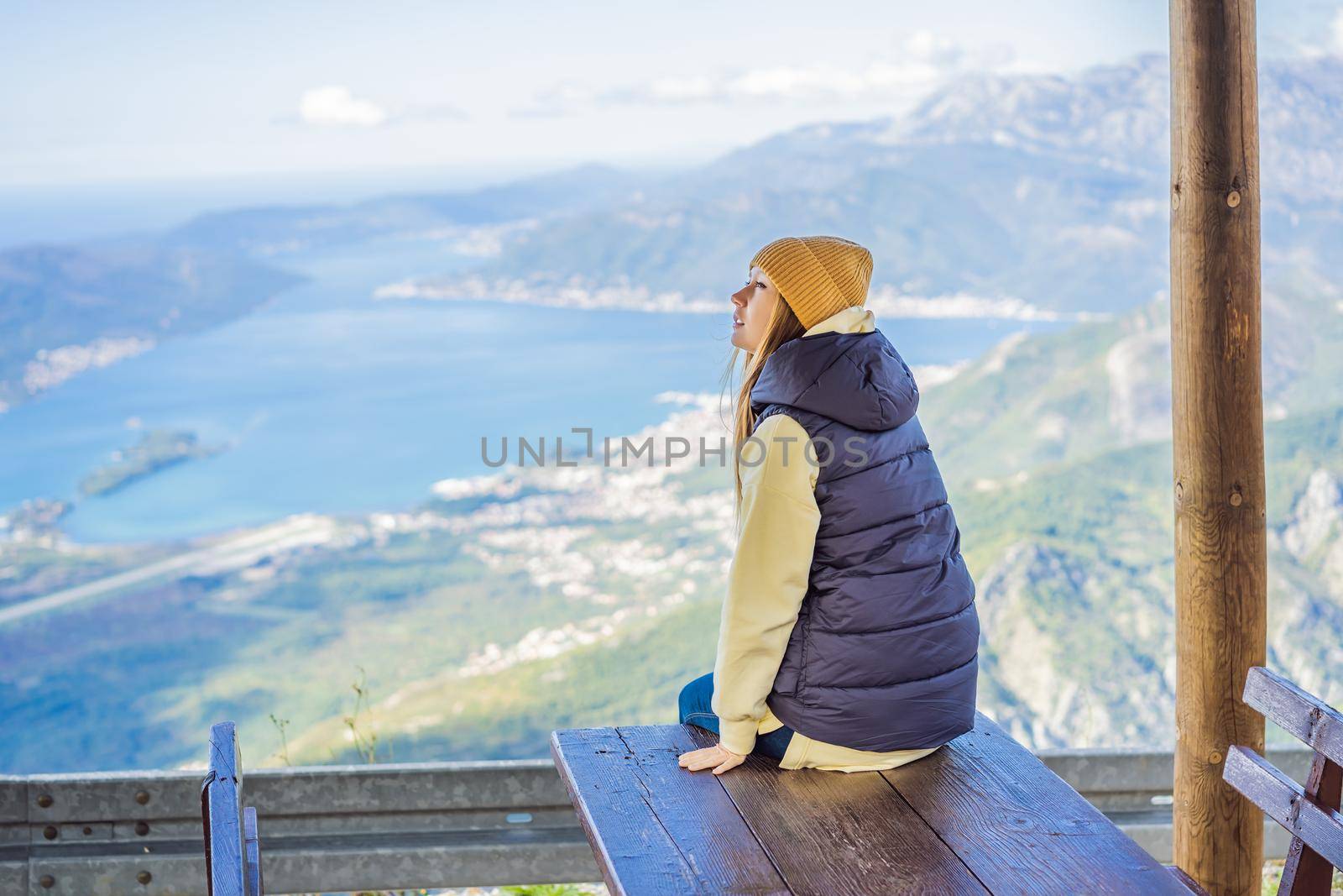 Woman tourist enjoys the view of Kotor. Montenegro. Bay of Kotor, Gulf of Kotor, Boka Kotorska and walled old city. Travel to Montenegro conceptFortifications of Kotor is on UNESCO World Heritage List since 1979.