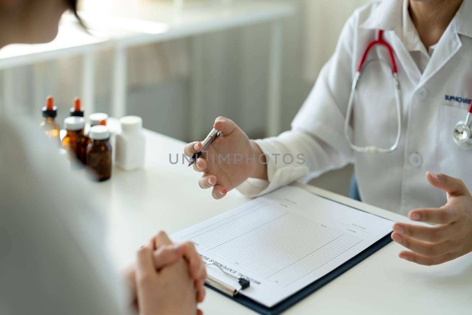 Asian female doctor in white medical uniform consult female patient in private hospital. woman therapist speak talk with woman client on consultation in clinic.