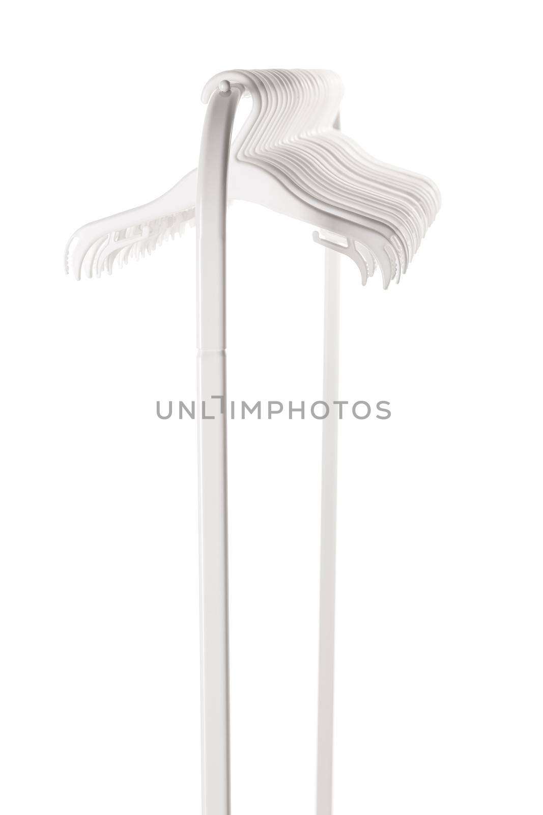 White plastic hangers for clothes hanging on rod from clothing rack. Isolated on white background.