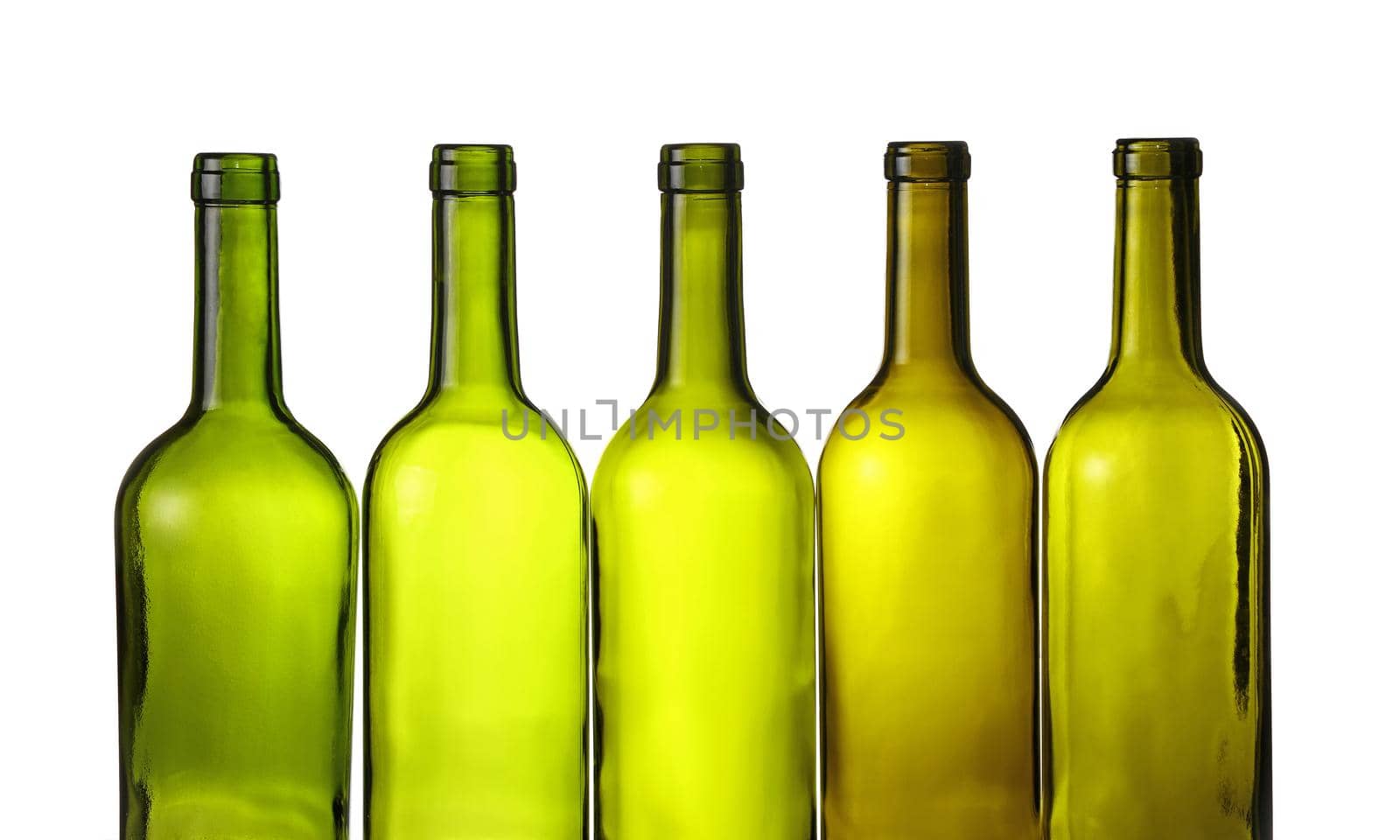 Close up group of five empty washed green glass wine bottles in a row isolated on white background, low angle side view