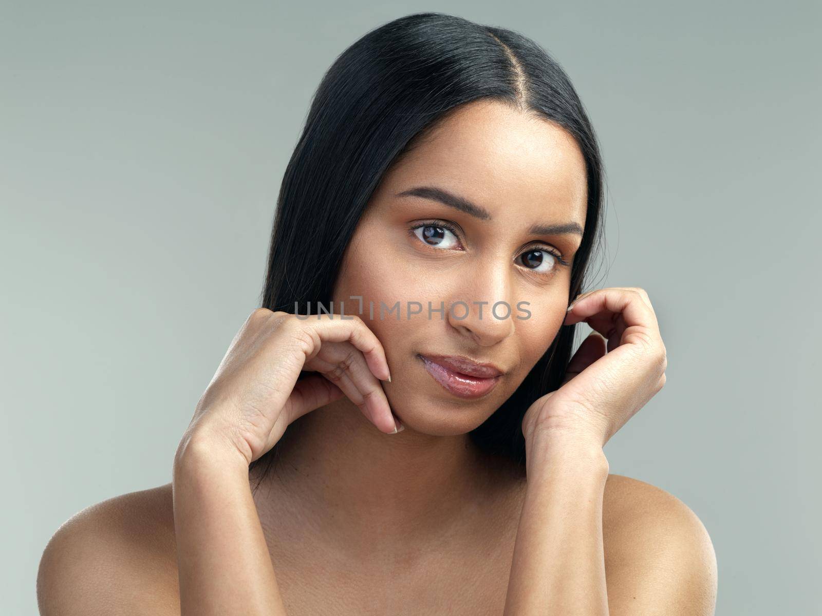 A good beauty regime will keep breakouts under control. Cropped shot of a beautiful young woman with flawless skin posing against a grey background. by YuriArcurs