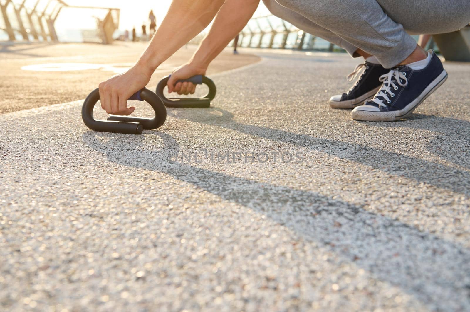 Cropped image of an athlete exercising outdoor, doing push-up exercises. Fitness, sport, endurance, body weight training, outdoor workout, healthy and active lifestyle concept by artgf