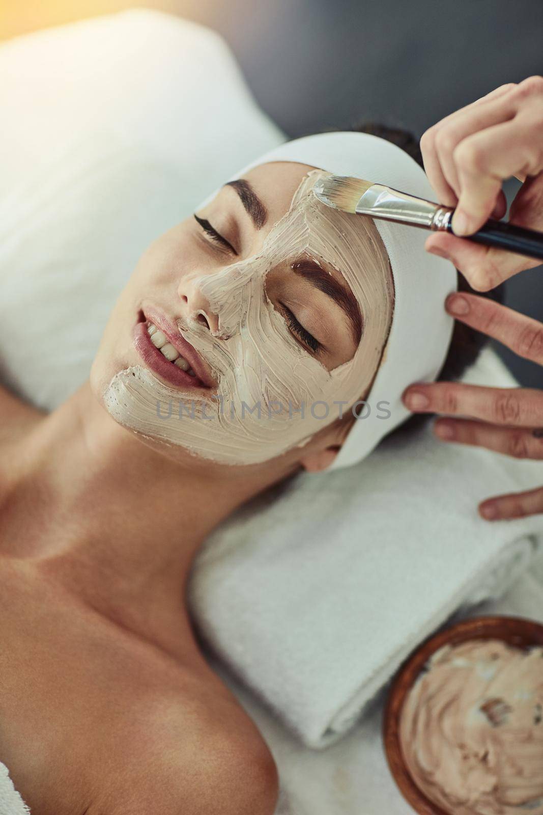 This is heavenly. Shot of an attractive young woman getting a facial at a beauty spa. by YuriArcurs