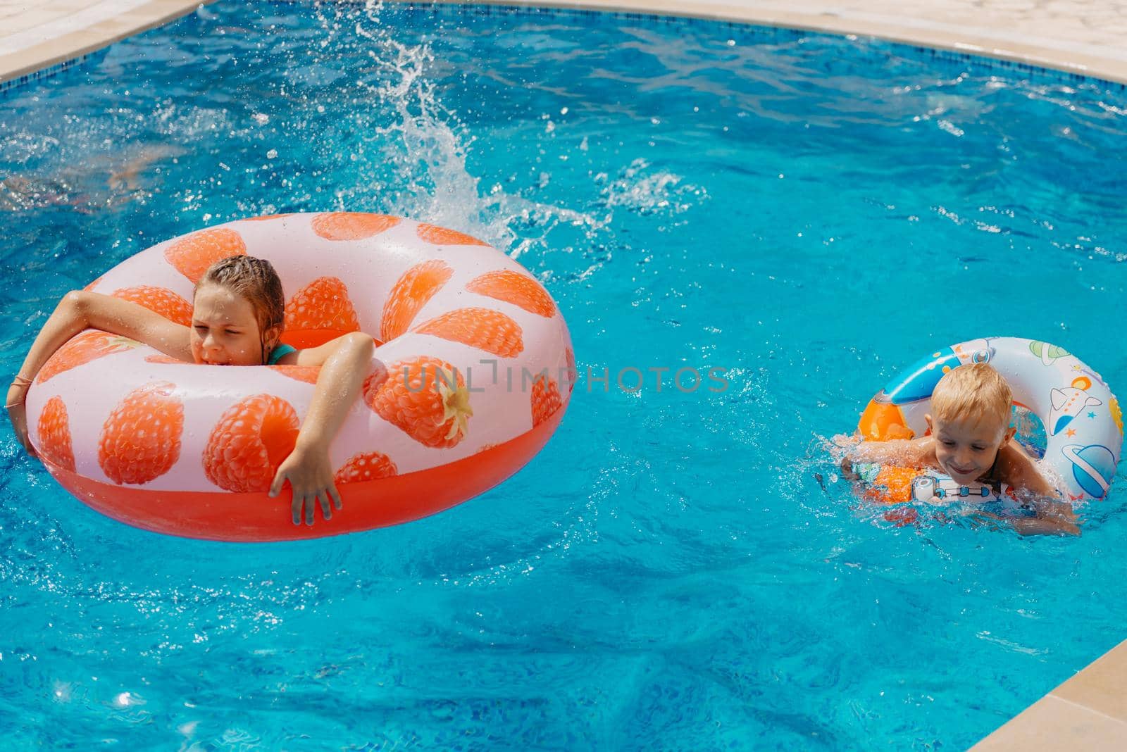 Happy child having fun on summer vacation. Kid playing with rubber duck and ball in the sea. Healthy lifestyle concept. Happy child playing in swimming pool. Summer vacations concept by Andrii_Ko
