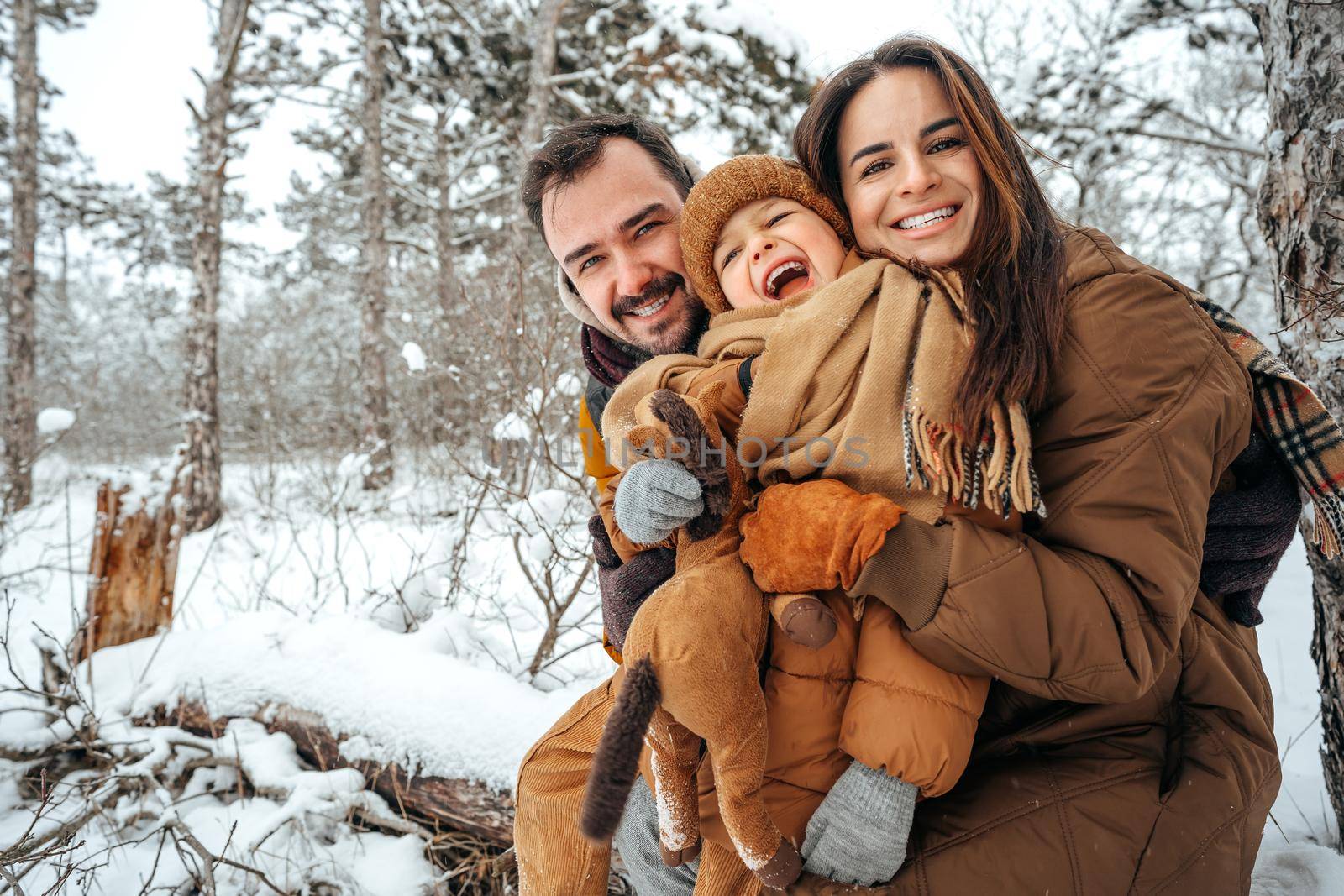 Portrait of happy family in winter clothes in snowy forest
