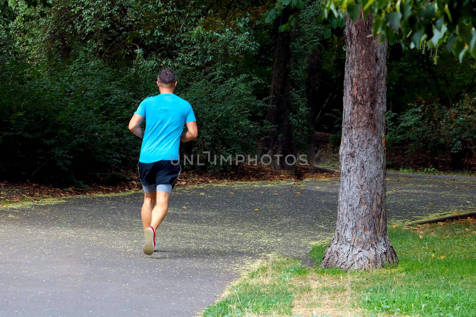 A view of a man running in the park. Sports