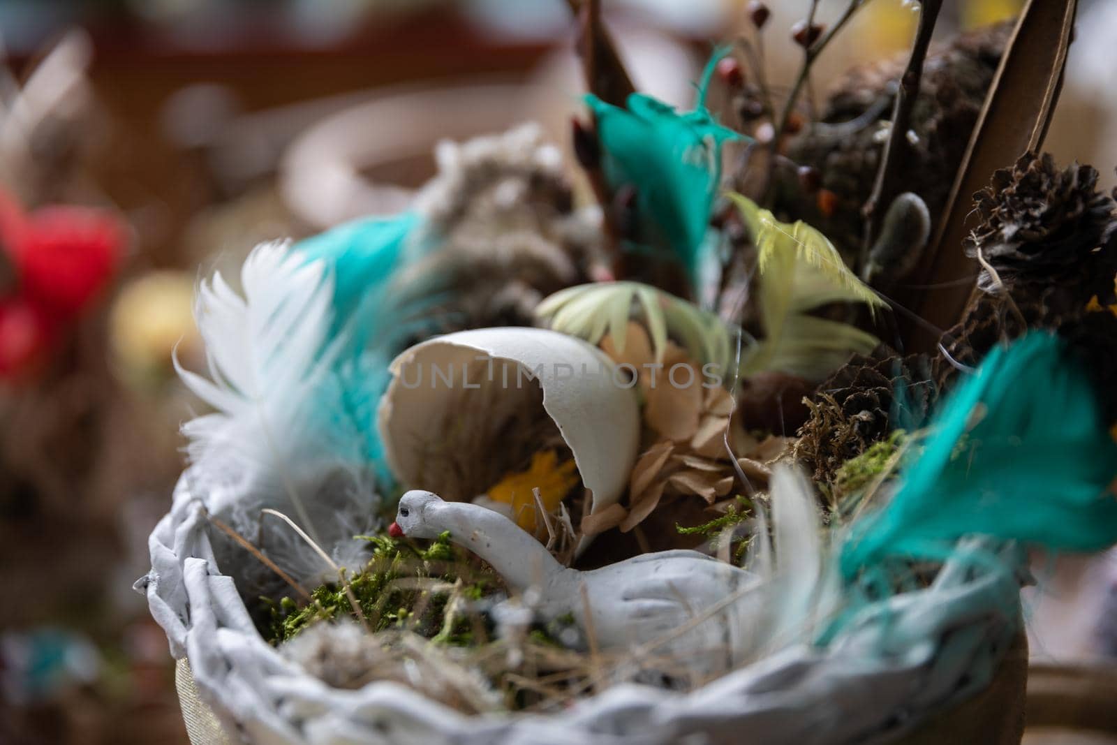 Easter decoration with swan sitting in nest next to half egg shell and hatched chick. Artistic Polish folk design.