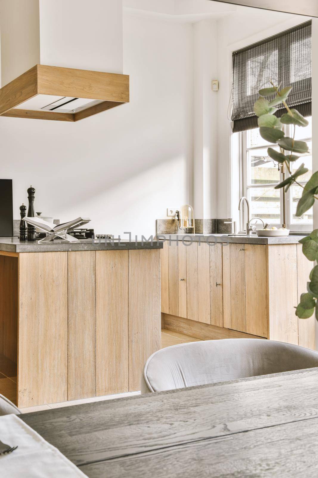 The interior of a spacious, bright kitchen with wooden furniture in a modern house