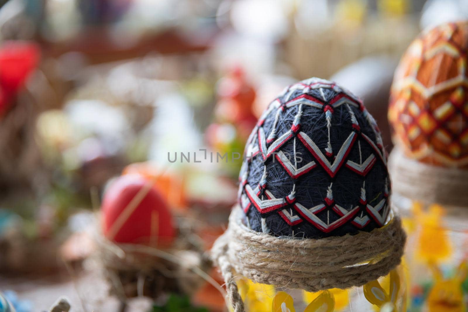 Handmade Easter egg decorated with colorful yarn in geometric shapes. Polish folk masterpiece.