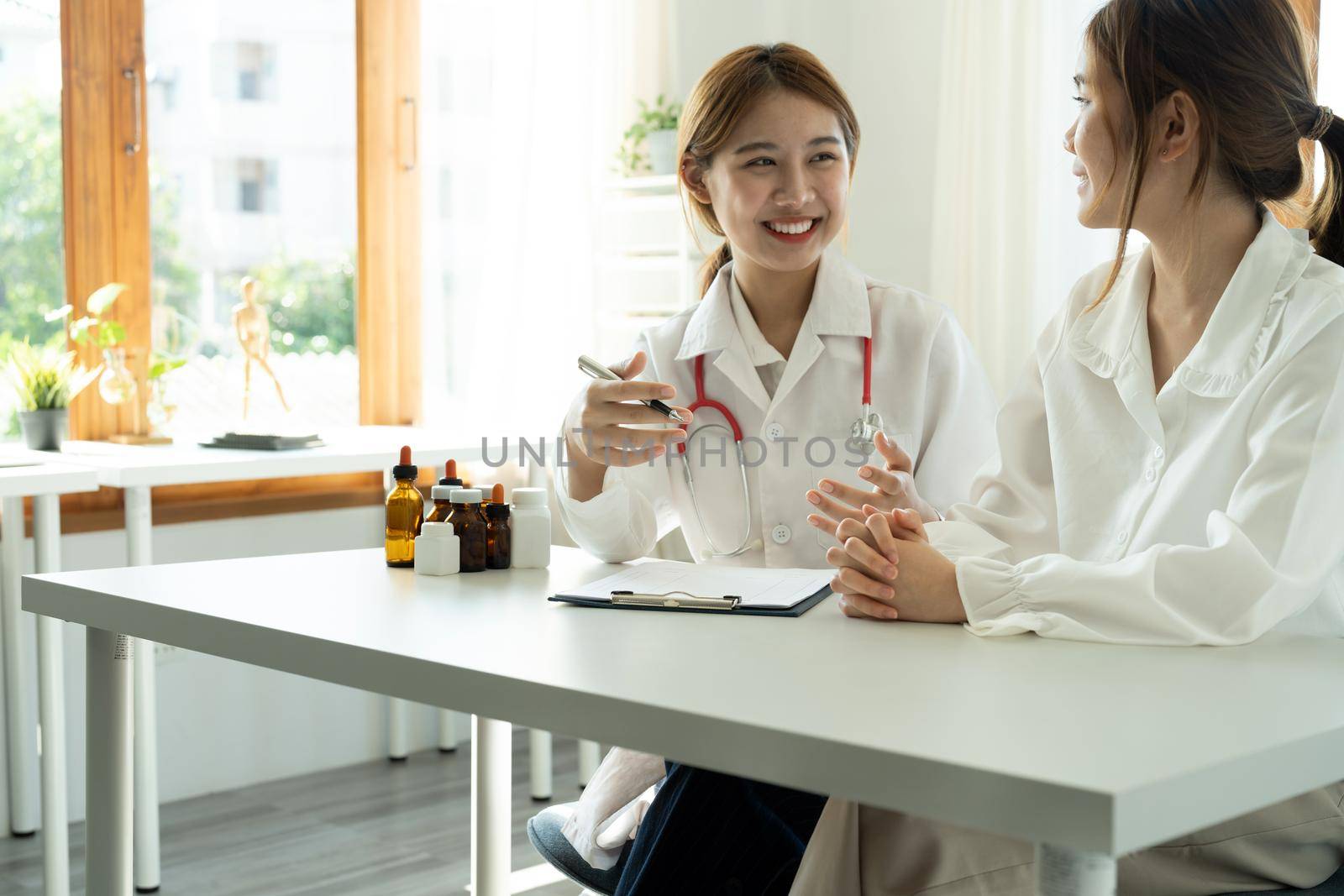Young asian doctor talking with her patient life insurance policy by nateemee
