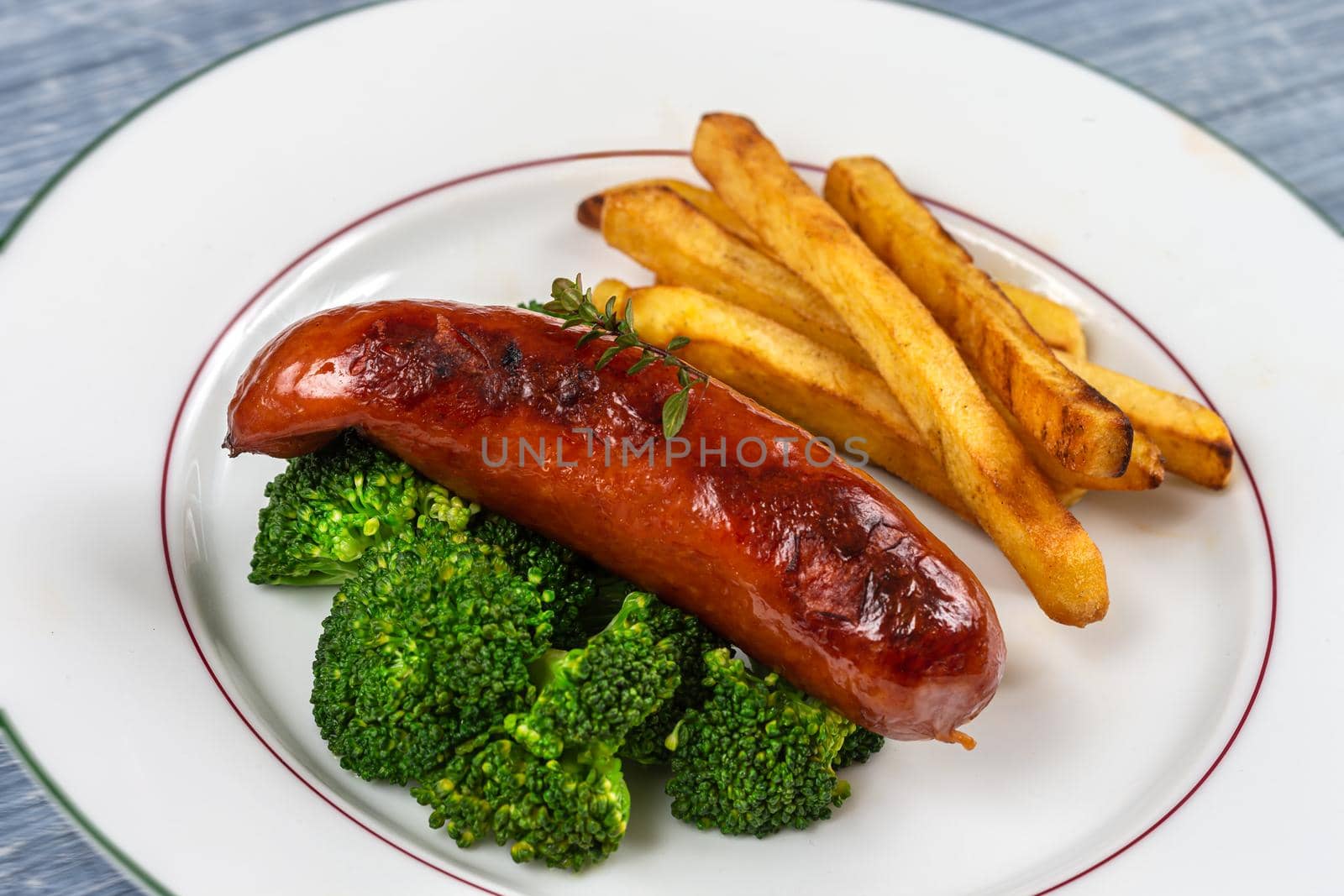 Montb liard sausage accompanied by broccoli and fries