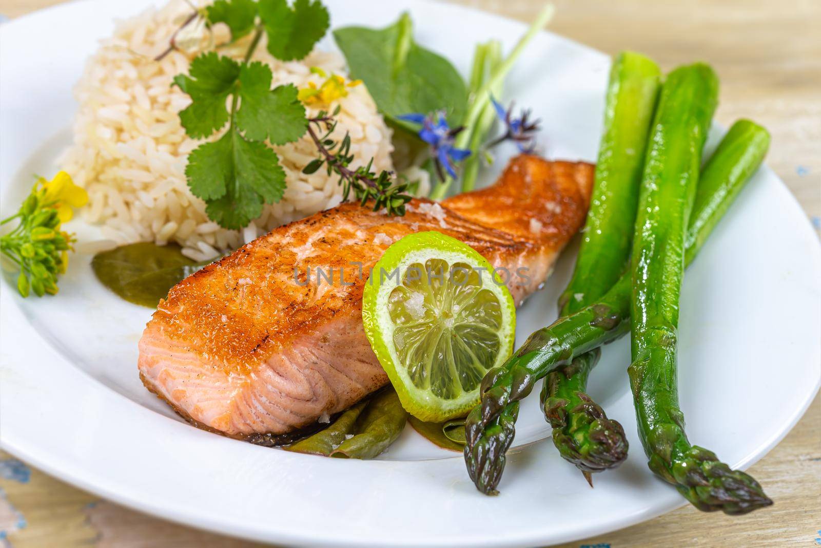Plate of salmon, asparagus and rice on standby wooden board by JPC-PROD