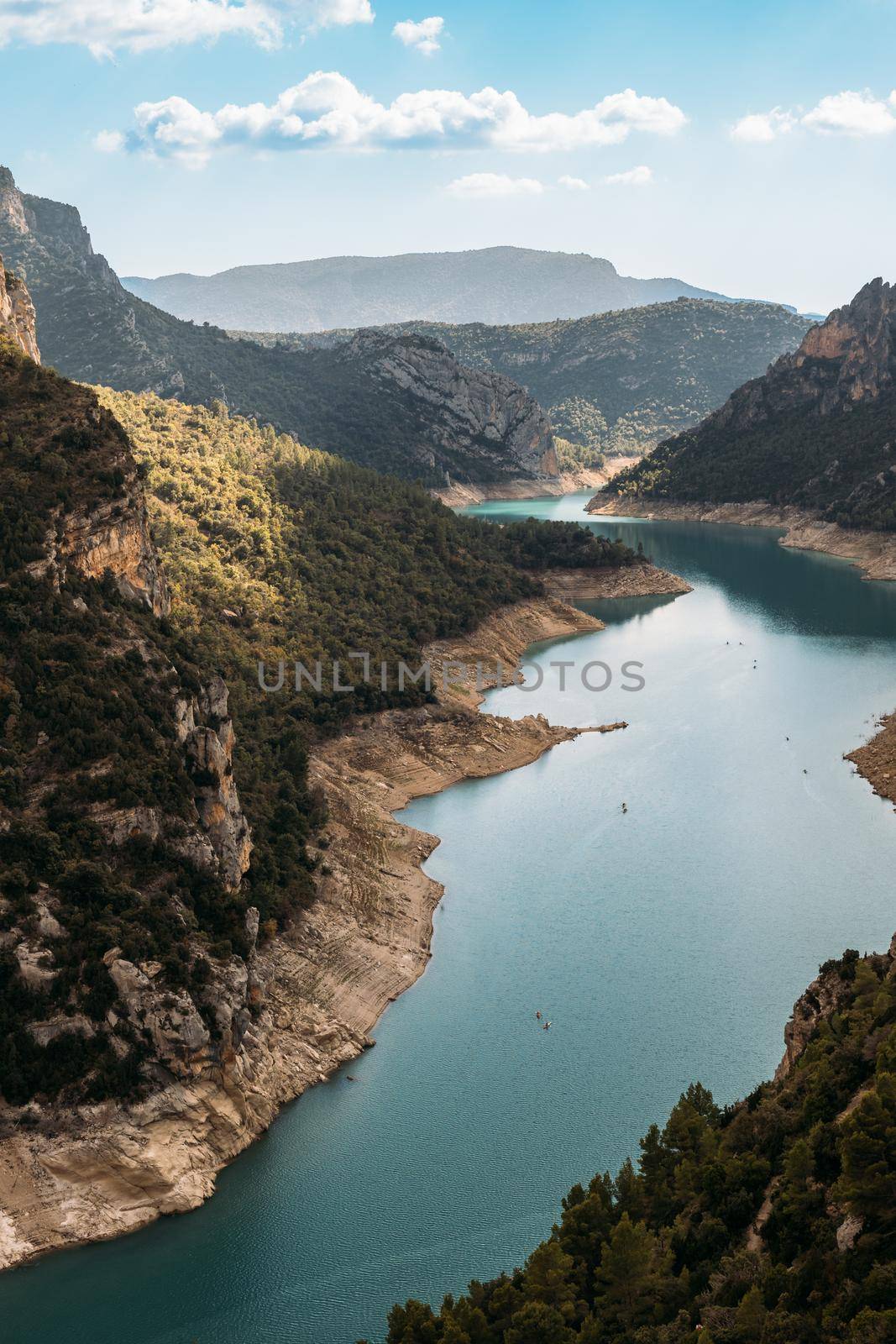 Beautiful landscape of forest woods and calm tranquil lake. Fat white clouds on blue sky