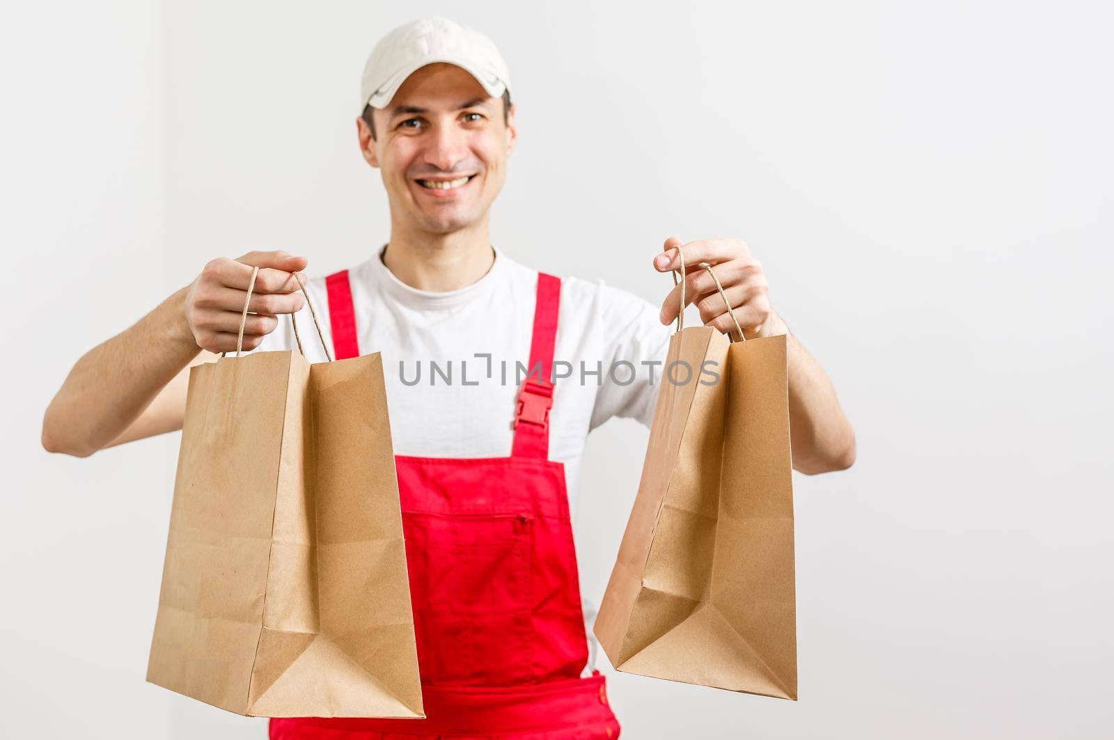 Diverse of paper containers for takeaway food. Delivery man is carrying