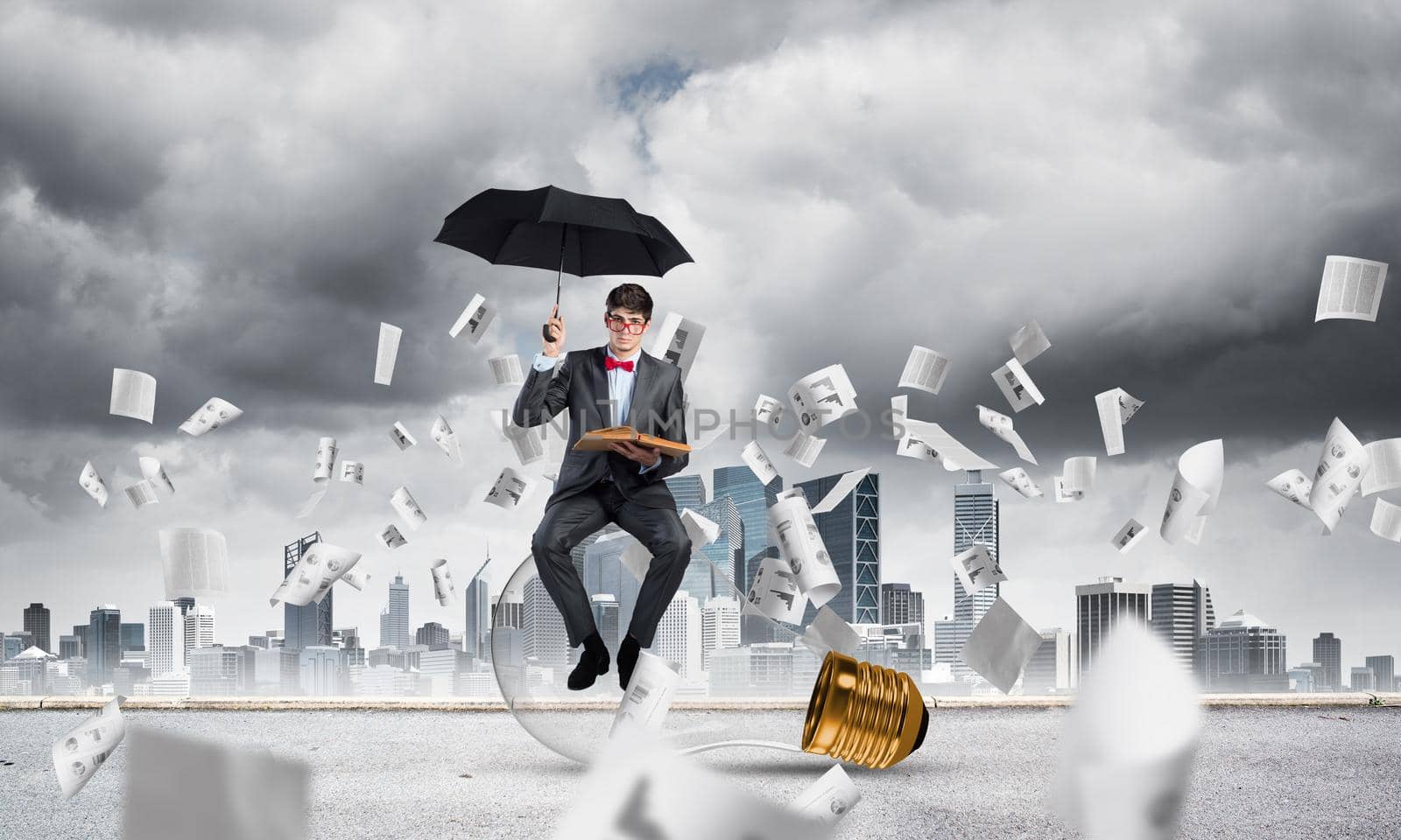 young businessman with umbrella and book, around fly in chaos documents