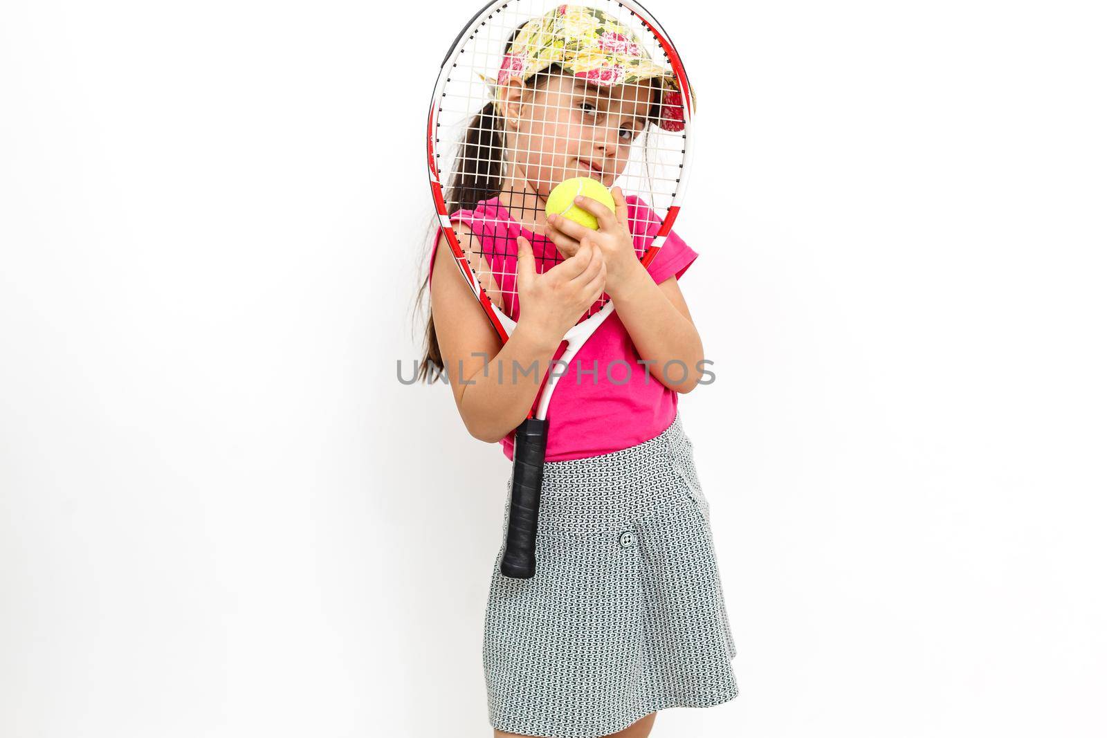 Cute little girl with tennis racket in her hands on white background