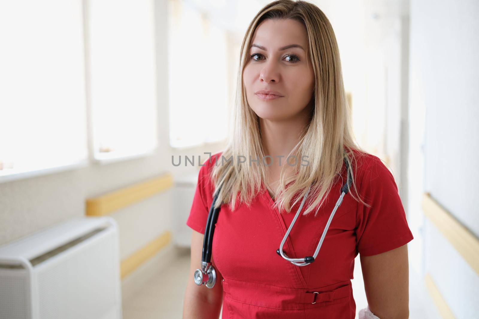 Portrait of young female doctor in corridor of hospital. Medical services and first aid concept