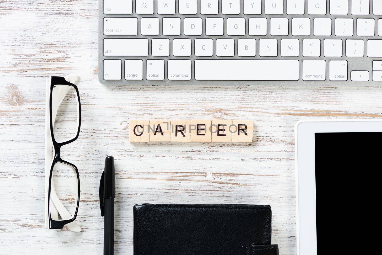 Career growth concept with letters on cubes. Still life of office workplace with supplies. Flat lay vintage wooden desk with computer keyboard and elegant glasses. Professional human resources hiring