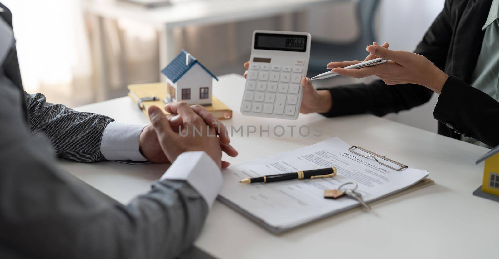 Real estate agent showing financial rate home loan for sign agreement customer the contract legally, Home sales and home insurance concept. by nateemee