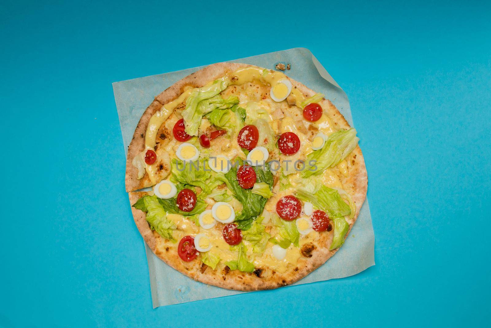 Close up of delicious hot pizza on light blue background. Selective focus.