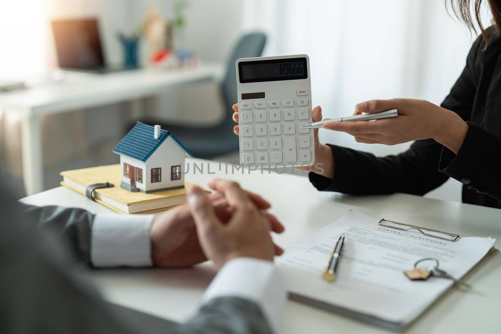 Real estate agent showing financial rate home loan for sign agreement customer the contract legally, Home sales and home insurance concept. by nateemee