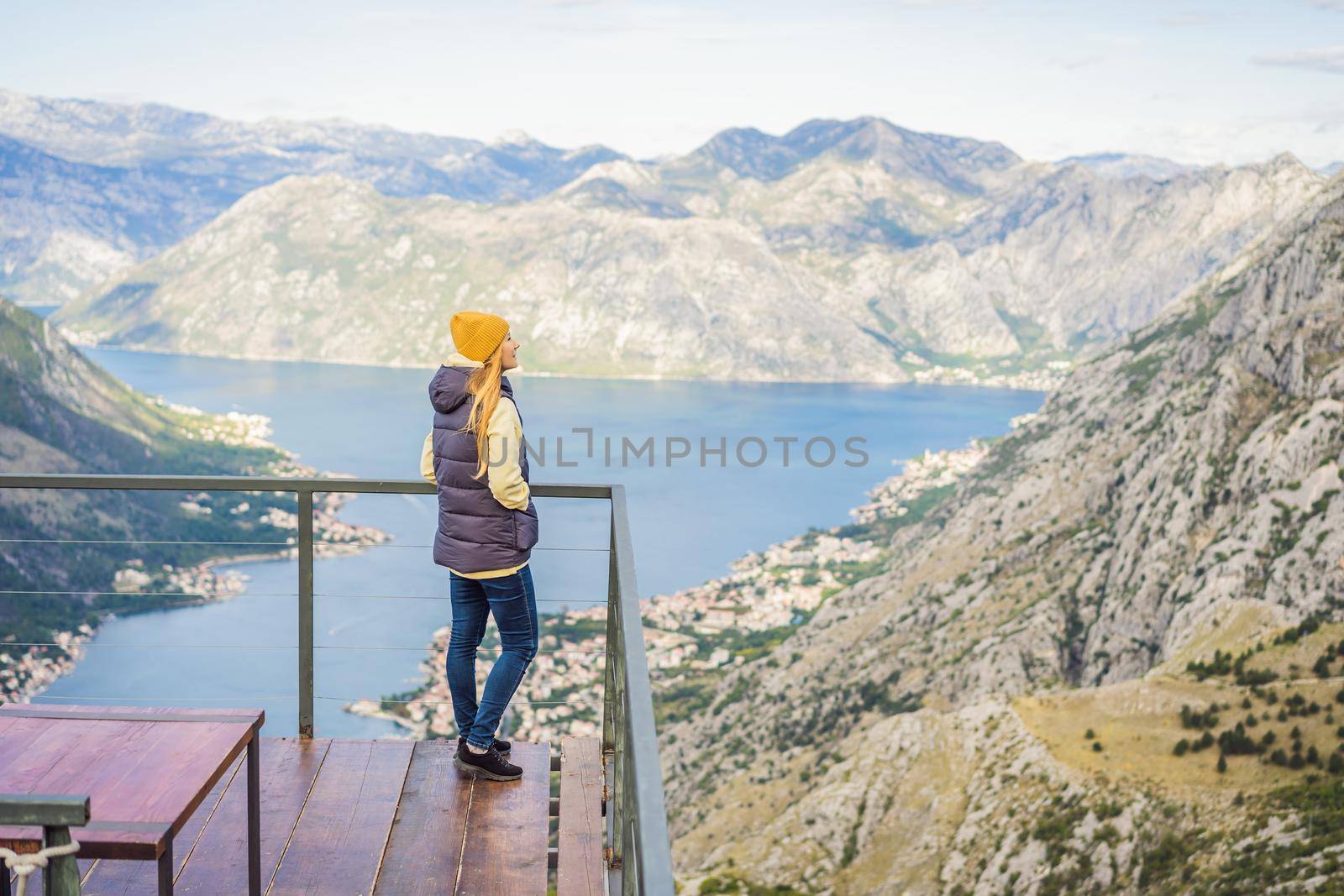 Woman tourist enjoys the view of Kotor. Montenegro. Bay of Kotor, Gulf of Kotor, Boka Kotorska and walled old city. Travel to Montenegro concept. Fortifications of Kotor is on UNESCO World Heritage List since 1979 by galitskaya