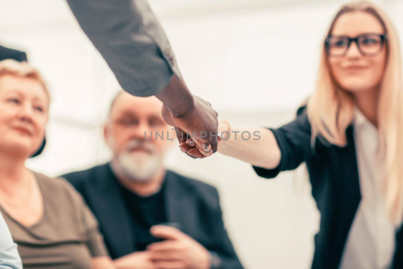 businessman and businesswoman shaking hands over the meeting table. business concept