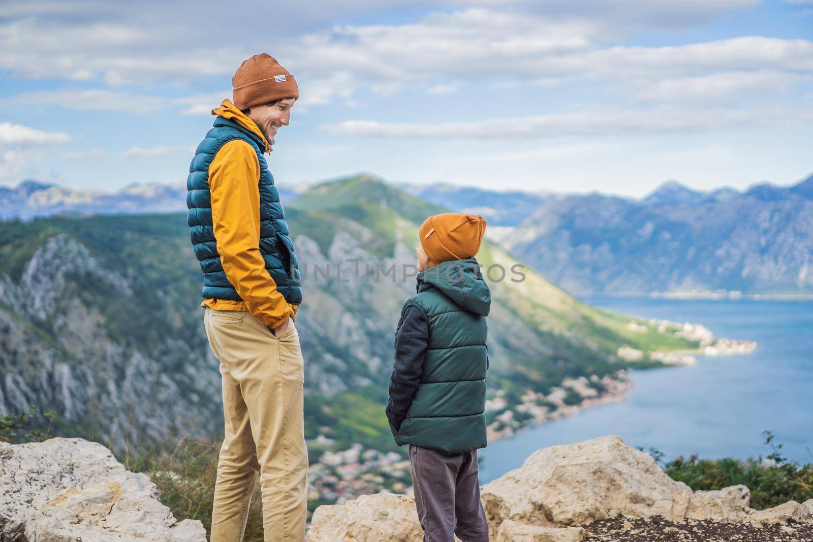 Dad and son travellers enjoys the view of Kotor. Montenegro. Bay of Kotor, Gulf of Kotor, Boka Kotorska and walled old city. Travel with kids to Montenegro concept. Fortifications of Kotor is on UNESCO World Heritage List since 1979.