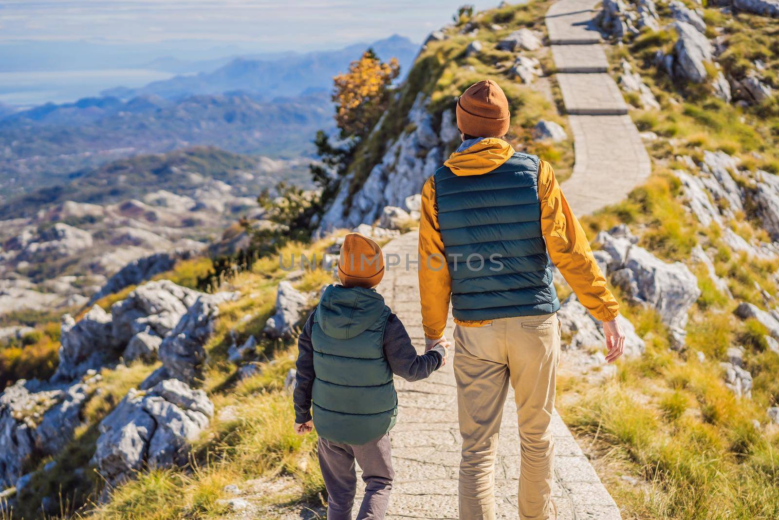 Dad and son travellers in mountain landscape at national park Lovcen, Montenegro. Travel to Montenegro with children concept.