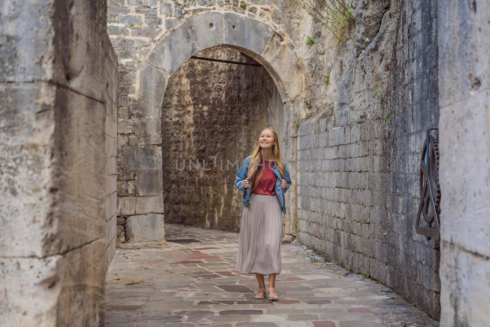 Woman tourist enjoying Colorful street in Old town of Kotor on a sunny day, Montenegro. Travel to Montenegro concept by galitskaya