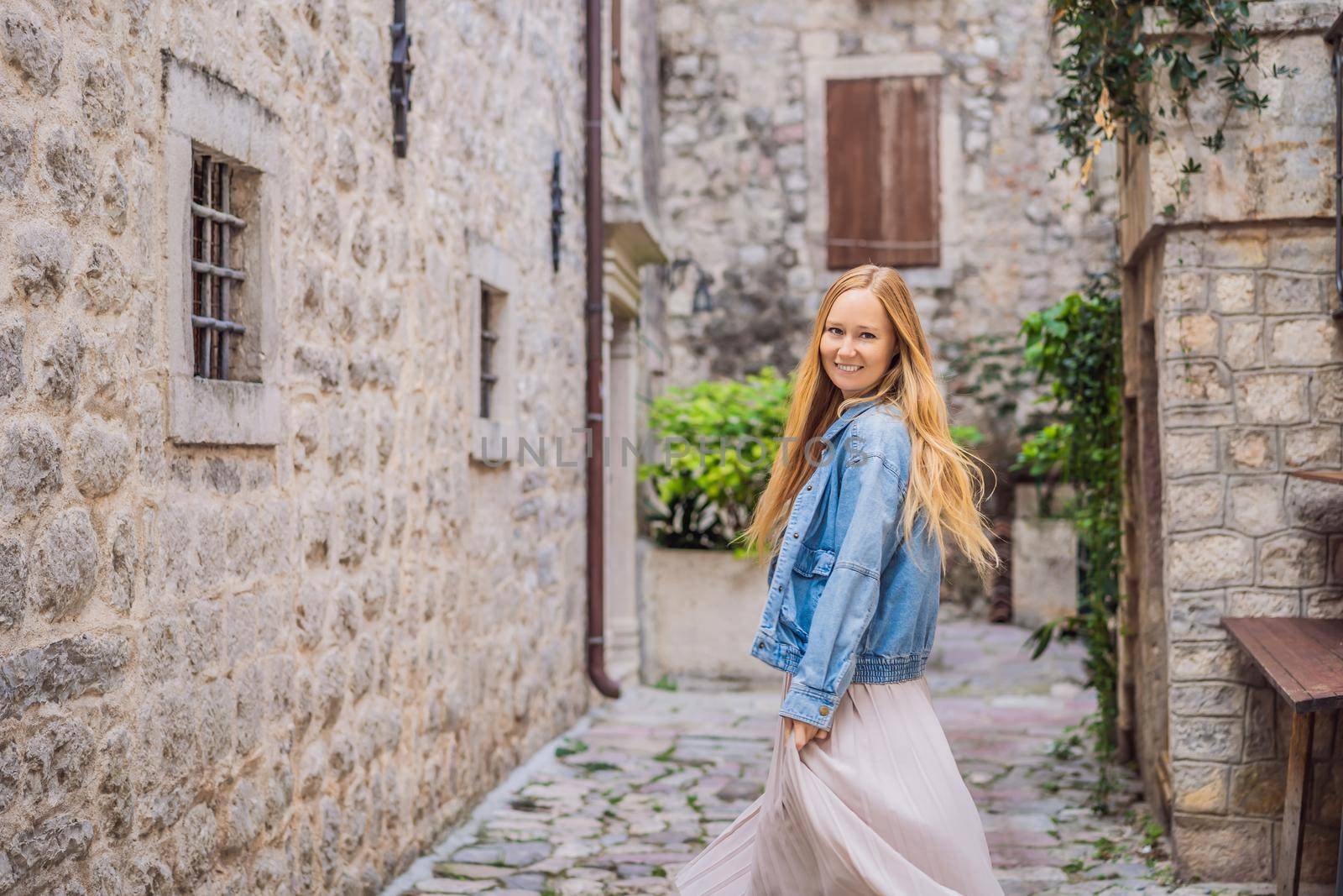 Woman tourist enjoying Colorful street in Old town of Kotor on a sunny day, Montenegro. Travel to Montenegro concept.