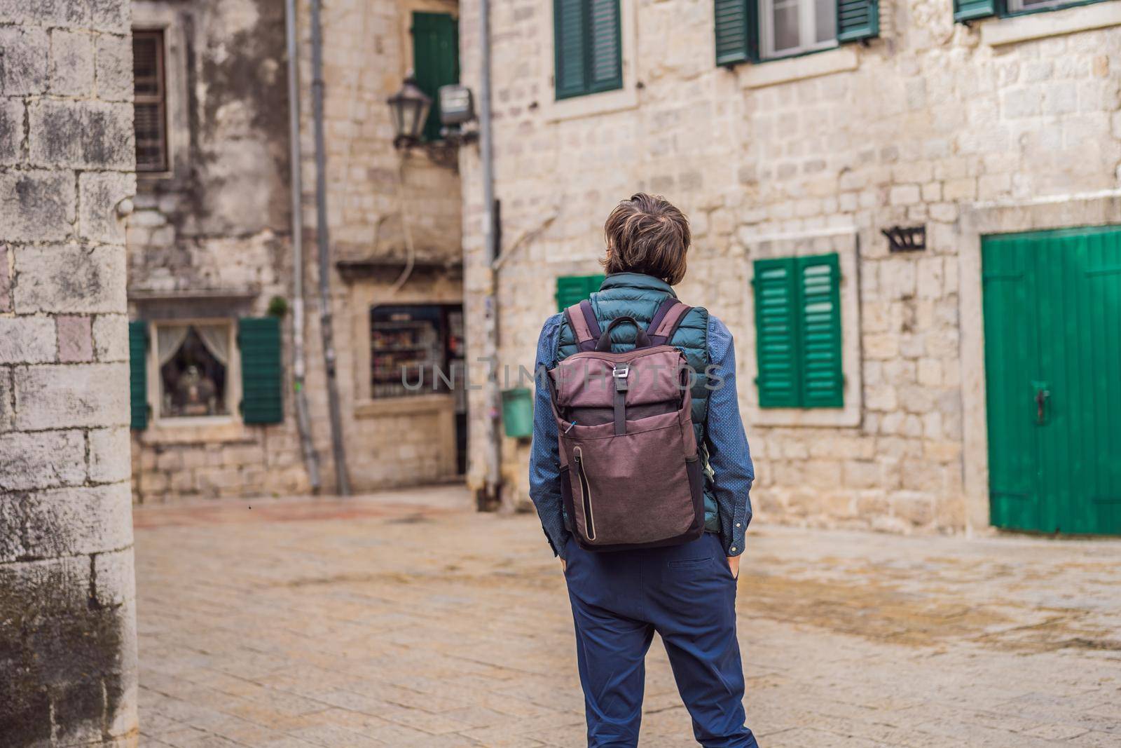 Man tourist enjoying Colorful street in Old town of Kotor on a sunny day, Montenegro. Travel to Montenegro concept.