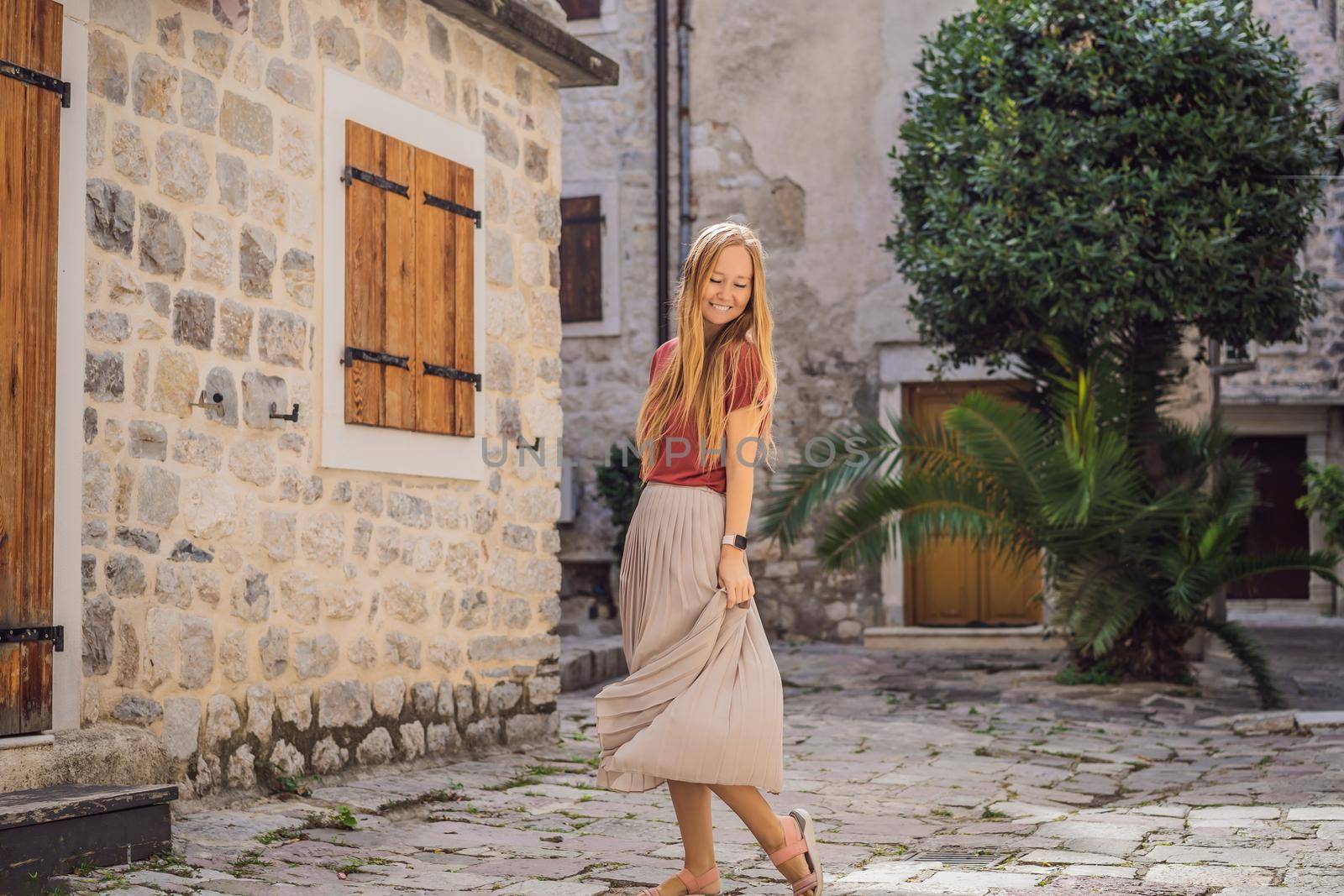 Woman tourist enjoying Colorful street in Old town of Kotor on a sunny day, Montenegro. Travel to Montenegro concept by galitskaya