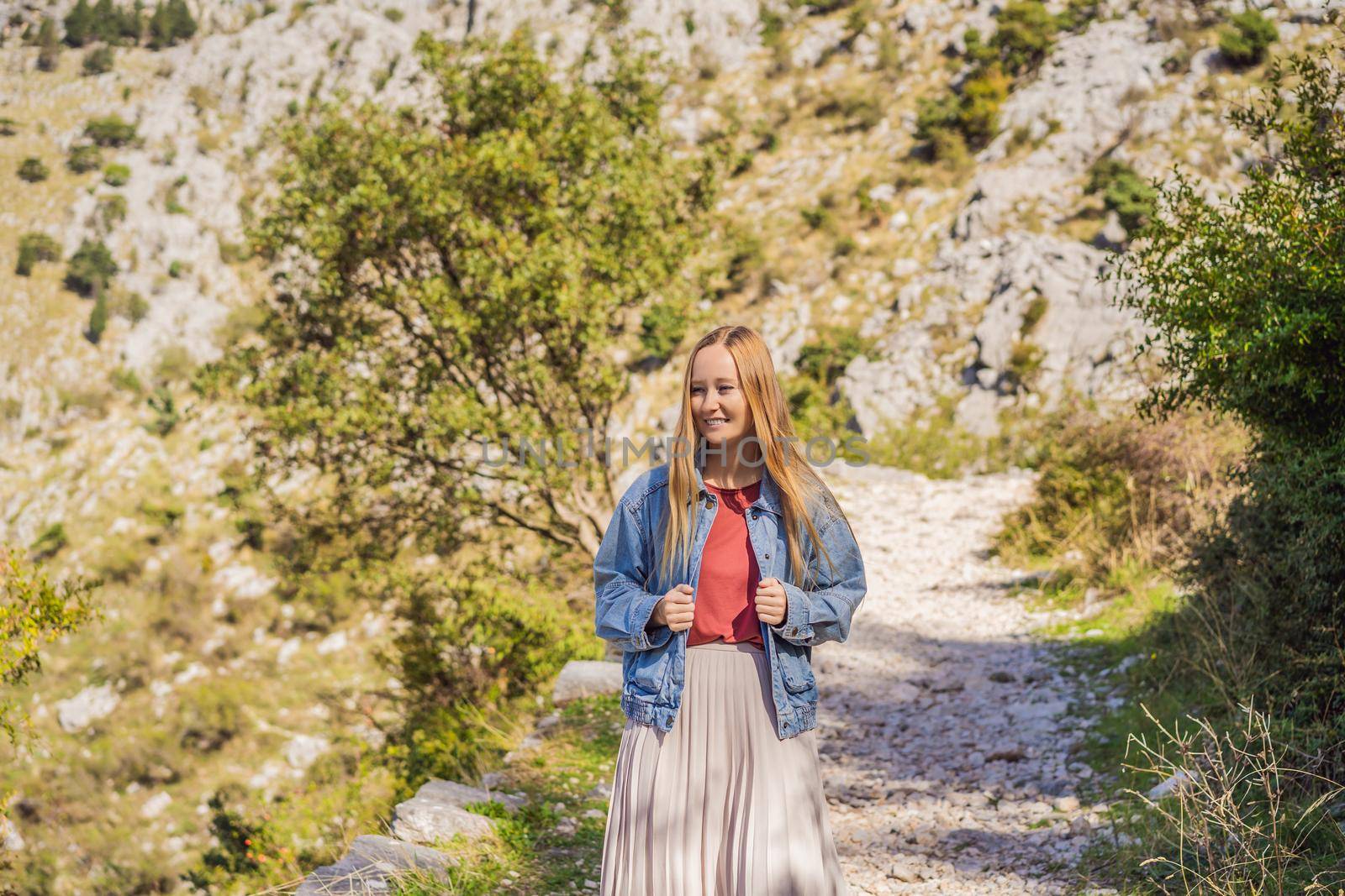 Woman tourist enjoys the view of Kotor. Montenegro. Bay of Kotor, Gulf of Kotor, Boka Kotorska and walled old city. Travel to Montenegro concept. Fortifications of Kotor is on UNESCO World Heritage List since 1979 by galitskaya