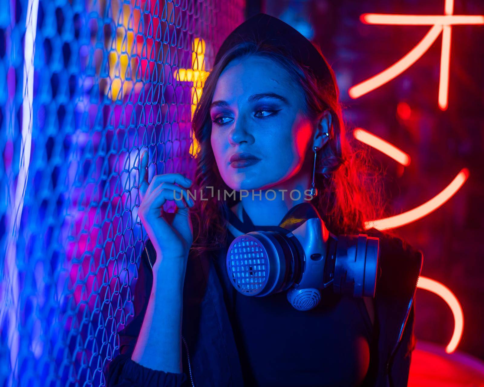 Caucasian woman with a gas mask in her hands in a neon studio