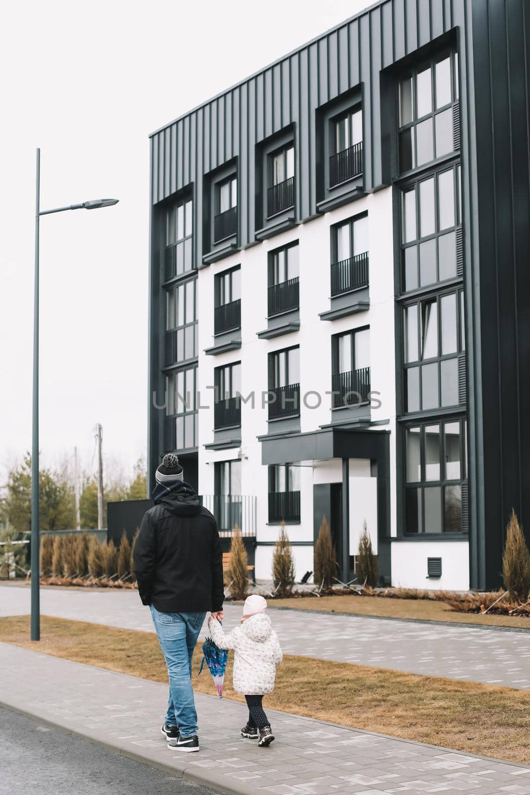 Father and daughter walking in the street together. Family having fun outdoors.